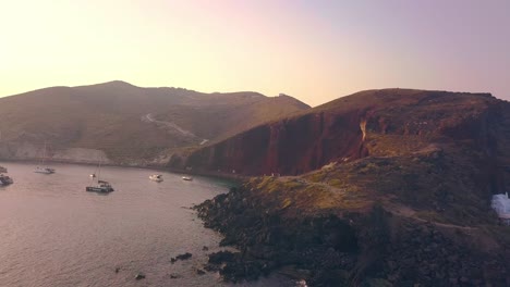 la playa de los acantilados rojos de santorini al atardecer