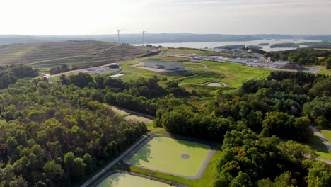 Reverse-aerial-of-landfill,-cesspool-and-sludge-in-retention-basin,-renewable-energy-and-waste-management-theme