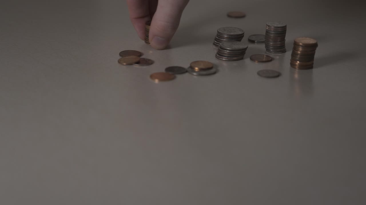 montones de centavos que se recogen de una mesa