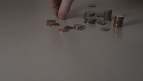 Stacks-of-pennies-being-picked-up-off-a-table