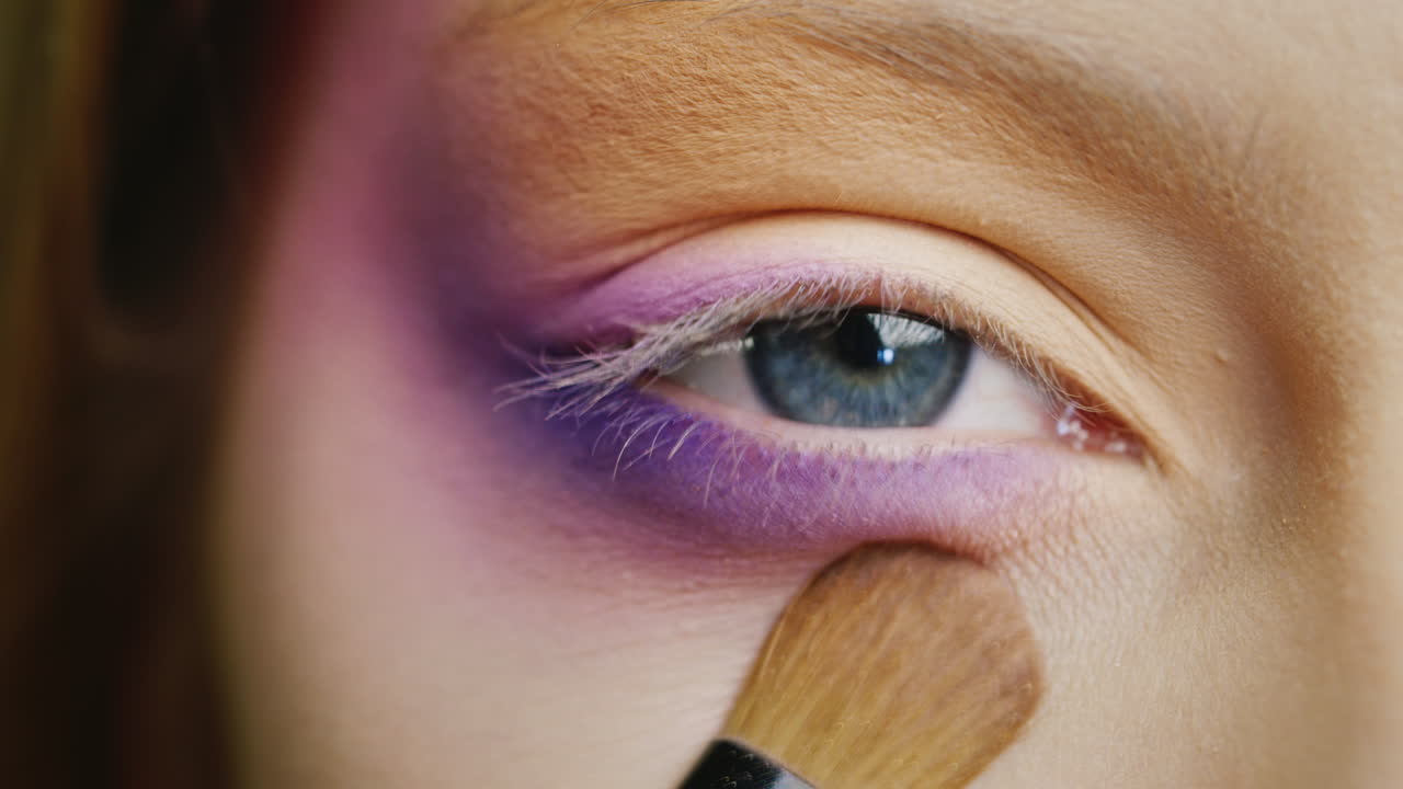 푸른 색의 아름다운 여성의 눈에 메이크업을 적용