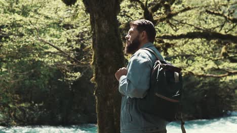 man hiking in the forest by a river