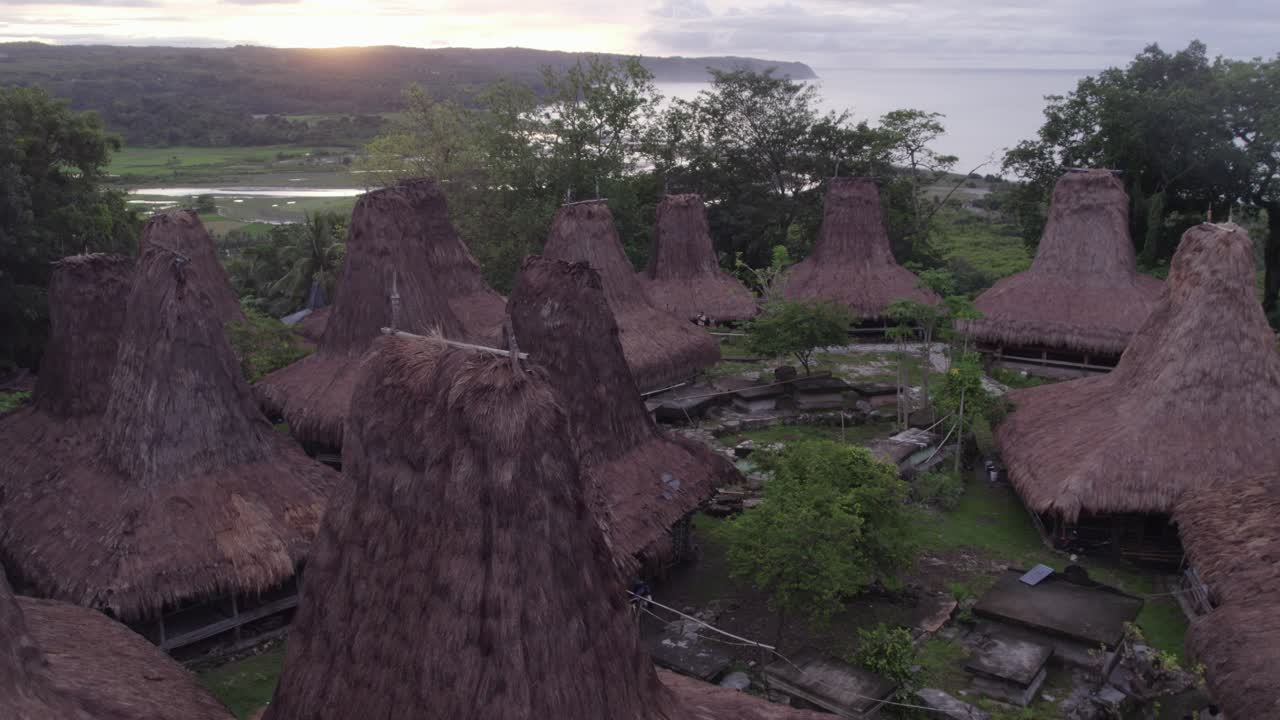 aviones no tripulados vuelan cerca de la aldea tradicional en sumba durante el amanecer, aérea