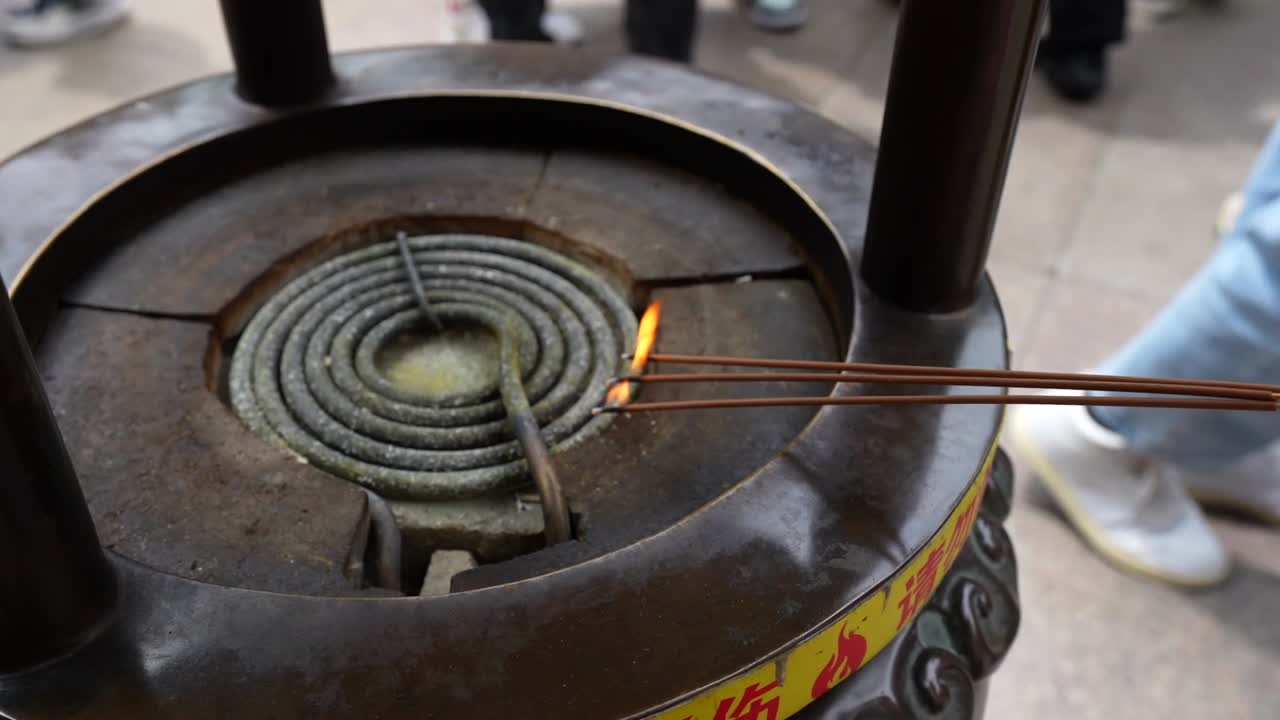Close up of burning incense sticks in a temple burner at Chenghuangmiao in Shanghai, China