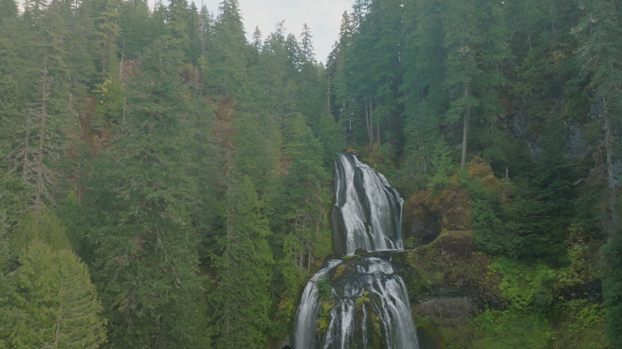 Falls Creek Falls in Gifford Pinchot National Forest, slow aerial rise, tilt down to base of waterfall.