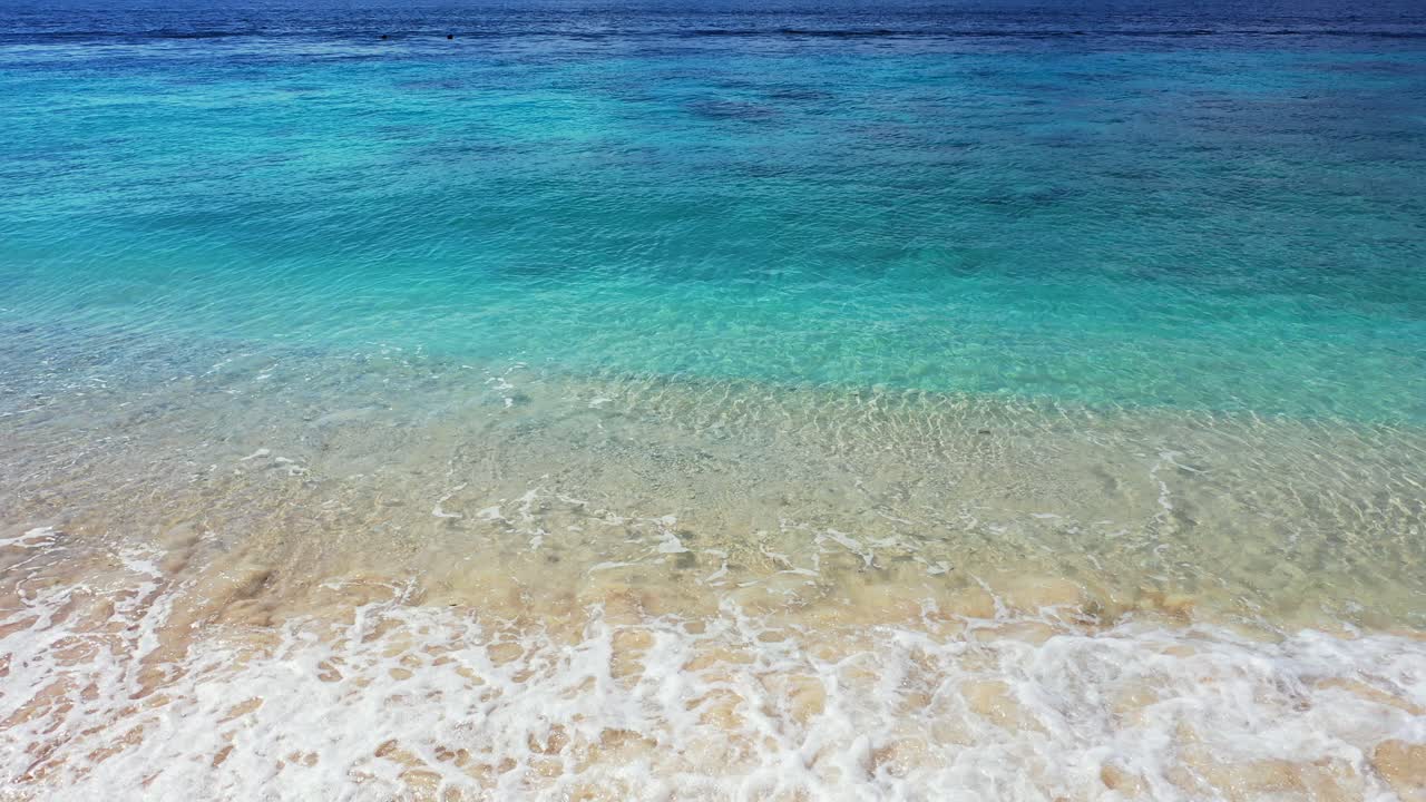 Beautiful texture of blue azure sea splashing white waves on sandy beach of coastline in Cook islands, copy space