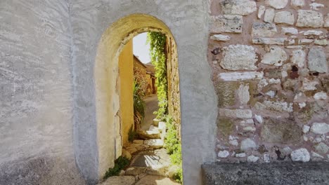 wall archway made of stone with green plants of a small village