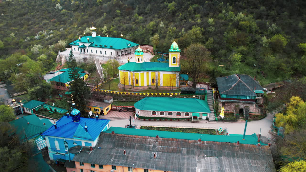 Aerial drone view of Saharna Monastery, Moldova. Monastery with churches located in a valley covered with lush forest