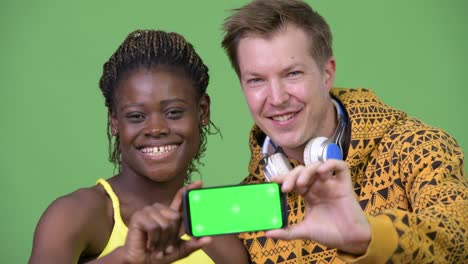 young multi-ethnic couple showing phone together