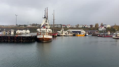 icelandic wooden typical boats moored in husavik port in rainy day