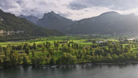 воздушный timelapse: пышные зеленые поля возле walensee окружены величественными горами, швейцария