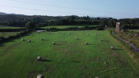 campo verde con pedazos de tronco cerca del antiguo acueducto romano ponte lupo, lazio, italia