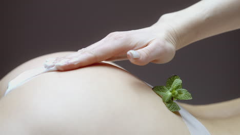 woman applying cream to her butt with mint