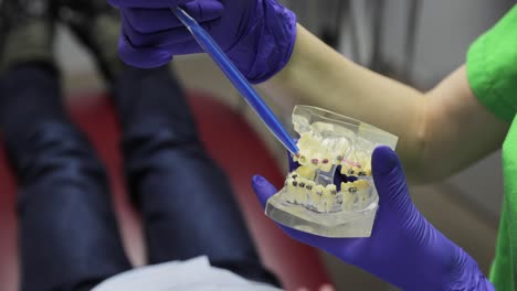 a dental assistant is demonstrating various tools and effective care techniques in a professional clinical setting.