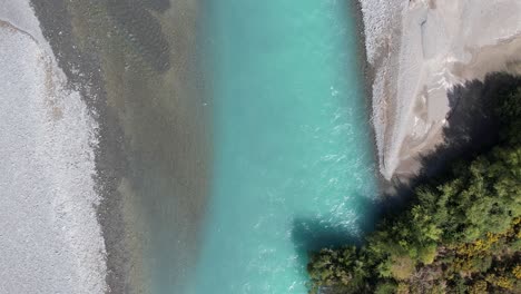 High-aerial-bird's-eye-view-of-beautiful-turquoise-colored-Waimakariri-River-in-slow-motion