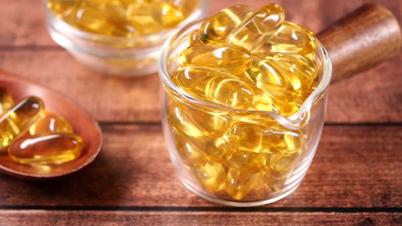 Capsule dorate di olio di pesce Omega 3 su sfondo di legno