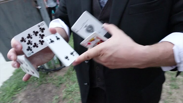 Mago che fa giochi di prestigio con le carte