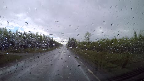 view from the car in the rain driving on wet roads. driving a car on a road in norway