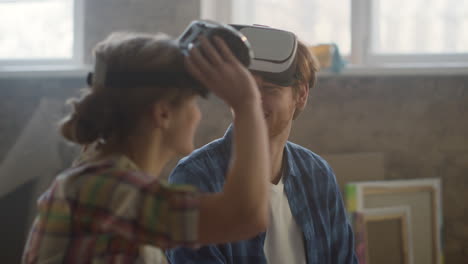 happy couple using vr glasses and modern technologies for house renovation.