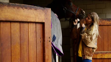 woman kissing horse in stable 4k