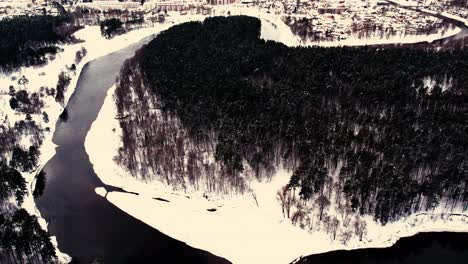 Ein-Gewundener-Fluss-In-Der-Nähe-Einer-Kleinen-Stadt-Mit-Einem-Waldmassiv