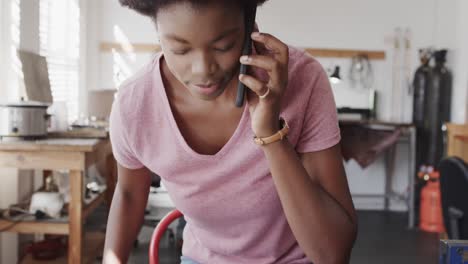 Busy-african-american-female-worker-talking-on-smartphone-in-jewellery-studio-in-slow-motion