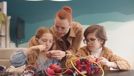 children and teacher building a robot in a stem workshop