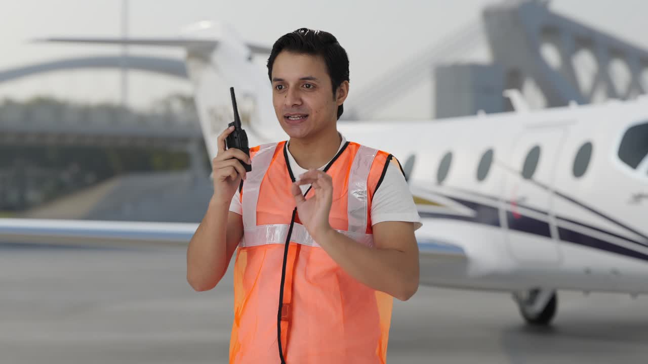 feliz trabajador del personal de tierra del aeropuerto indio dando instrucciones en walkie talkie