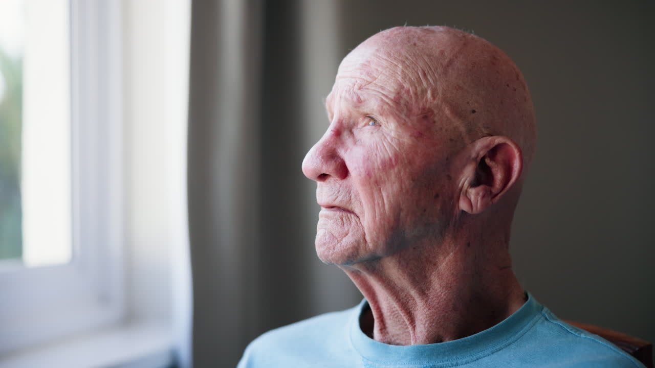 Portrait of an elderly man looking out the window