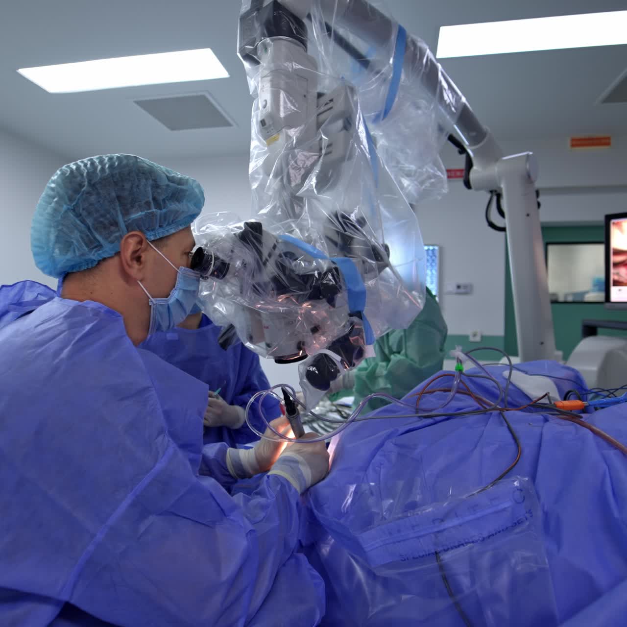 Nowadays neurosurgical operation in modern clinics. Doctor looks at microscope and operates the patient using up-to-date instruments and devices