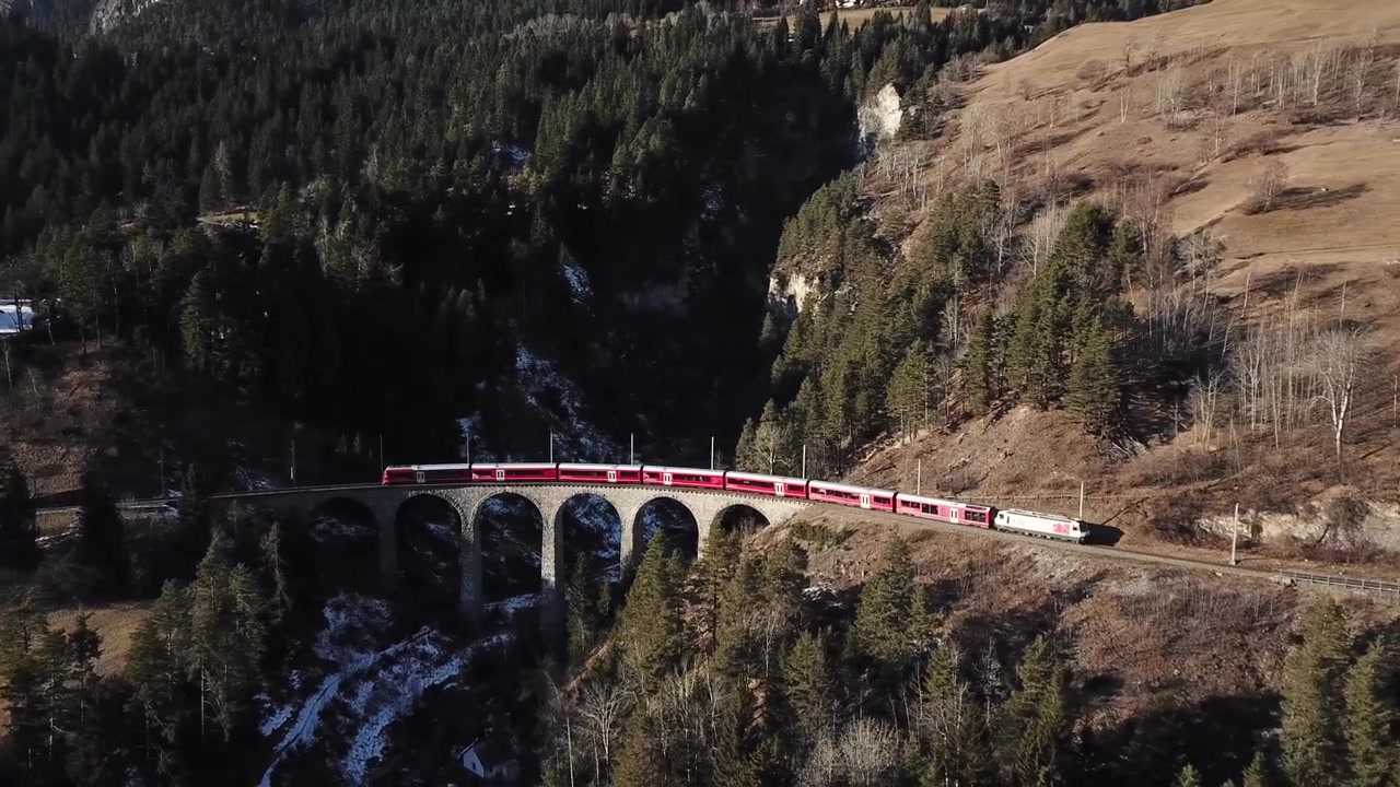 Veduta aerea del Viadotto di Landwasser e del Treno Rosso (Rhätische Bahn) che passa (Landwasserviadukt) nel Cantone dei Grigioni, Svizzera