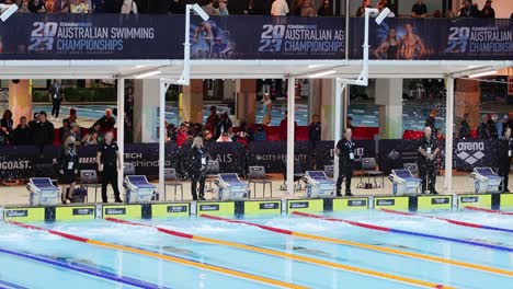 competitive swimmers race in a pool at an event