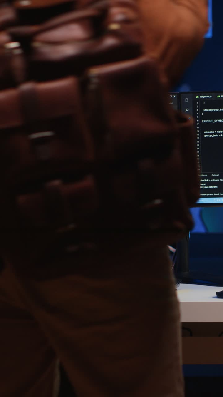 Man Coding on Dual Monitors in Dark Office