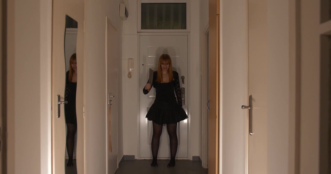Creepy sexy girl with a cleaver in a dark hallway, full shot