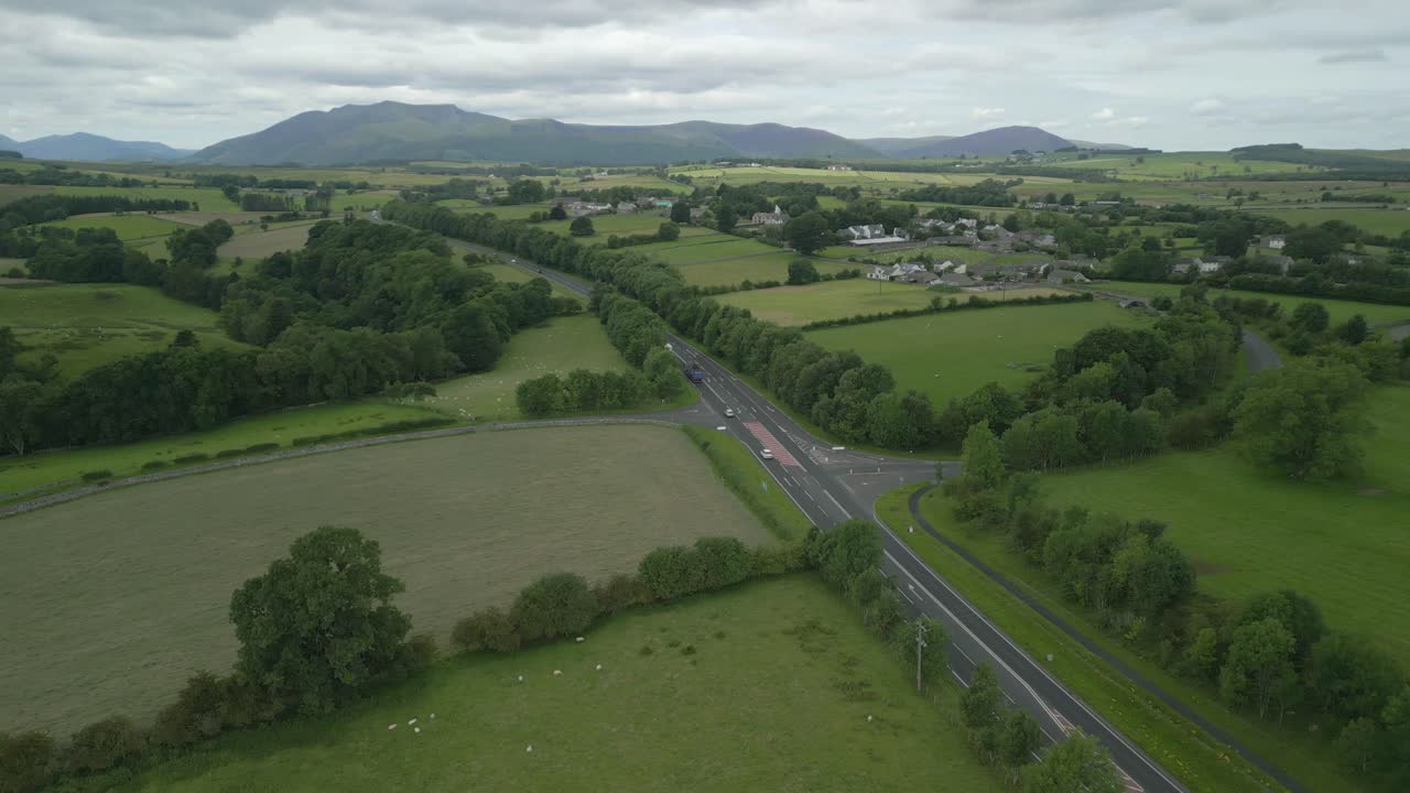 바쁜 시골 도로 a66 멀리 산 블렌카트라와 푸른 패치워크 필드와 함께 구름진 여름 날