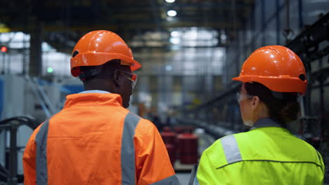 facility colleagues discussing project work at modern special huge factory.