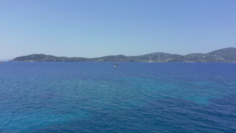 Aerial:-Slow-orbit-shot-of-a-motorised-Sailboat-in-the-open-blue-sea