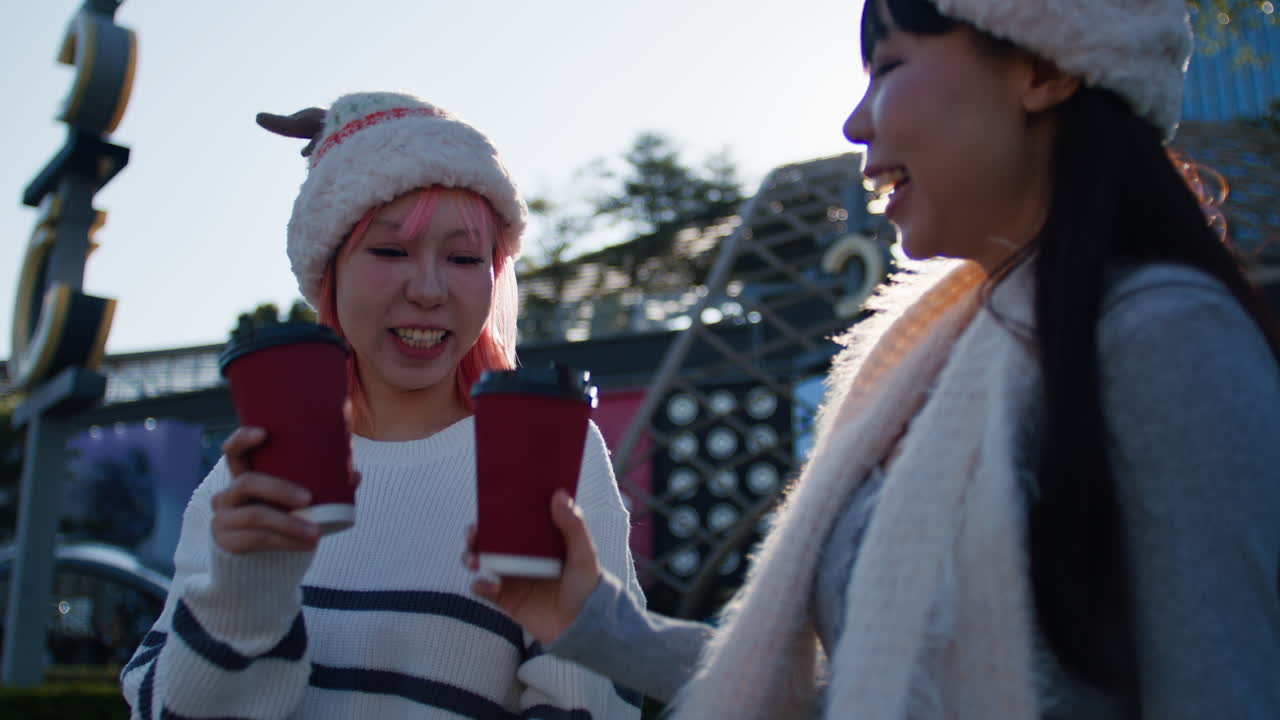 Two women laughing with coffee cups