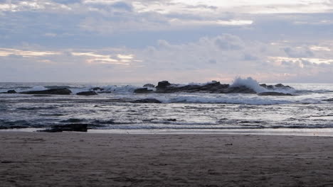 Calm-ocean-waves-crash-onto-sand-beach-rocks-on-Nicaragua-coast