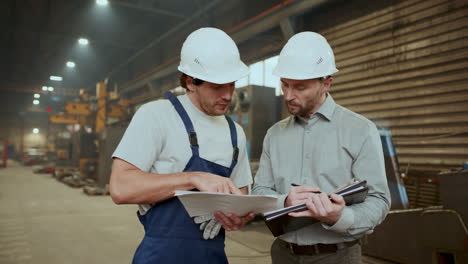 engineer shaking hands and discussing factory equipment with technician