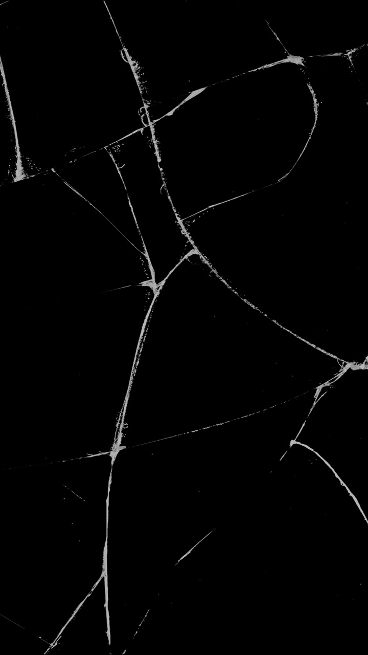 A static pattern of sharp cracks on glass, isolated on a black background. A vertical overlay for themes of damage, accidents, or destruction