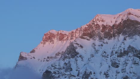 Witness-the-majestic-scene-of-sunrise-over-a-snow-clad-mountain-range-silhouette-from-this-captivating-drone-perspective