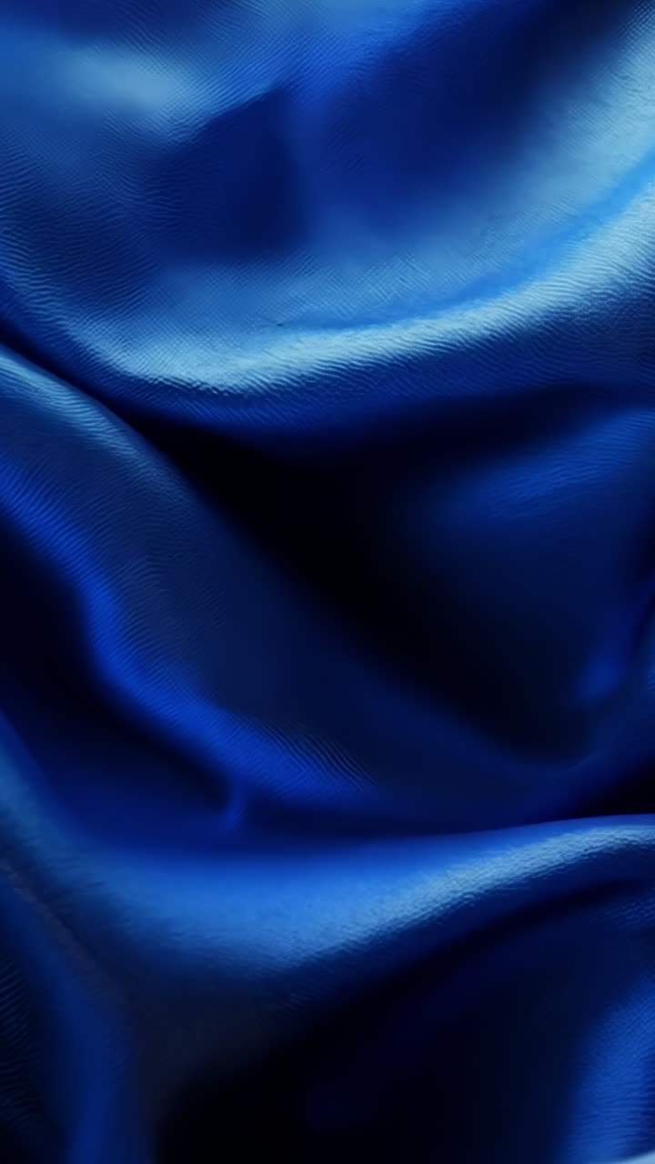 A blue fabric with a wave pattern. The wave pattern is very prominent and the fabric is very smooth