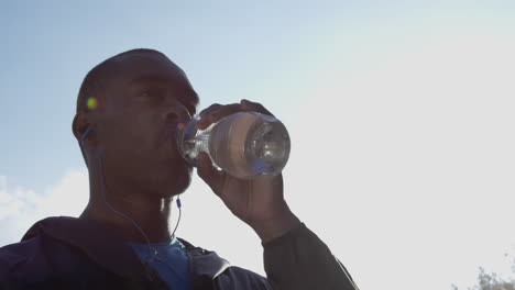 runner man drinking water bottle sun flare solar energy