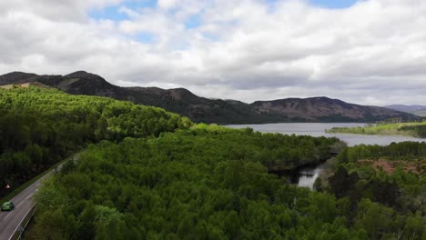 Aerial-panning-left-shot-of-a-Loch-with-Mountains-in-the-background-taken-in-the-Scottish-Highlands