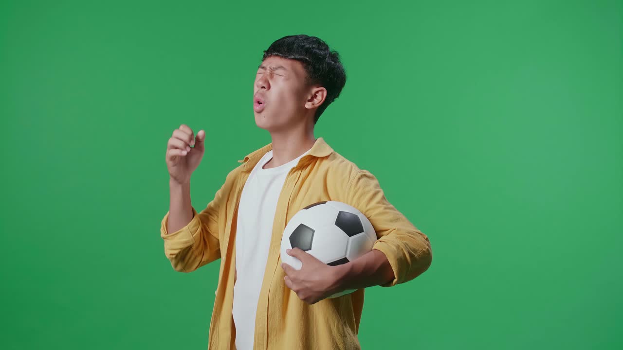 축구공을 들고 있는 젊은 남자, 불만족한 표정