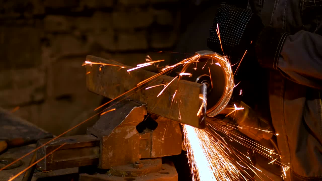 кузнец пилает металл ручной круговой пилой