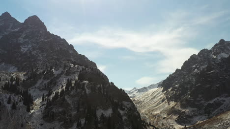 cinematic rotating drone shot of snow covered peaks of the trans-ili alatau mountains in kazakhstan