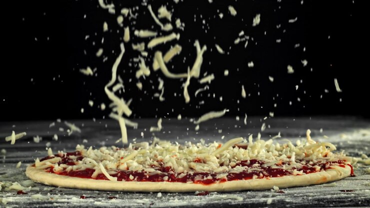 Rallentatore di mozzarella sfilacciata che cade sull'impasto della pizza.