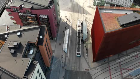 public tramway stopping at station near downtown buildings in gothenburg, aerial view